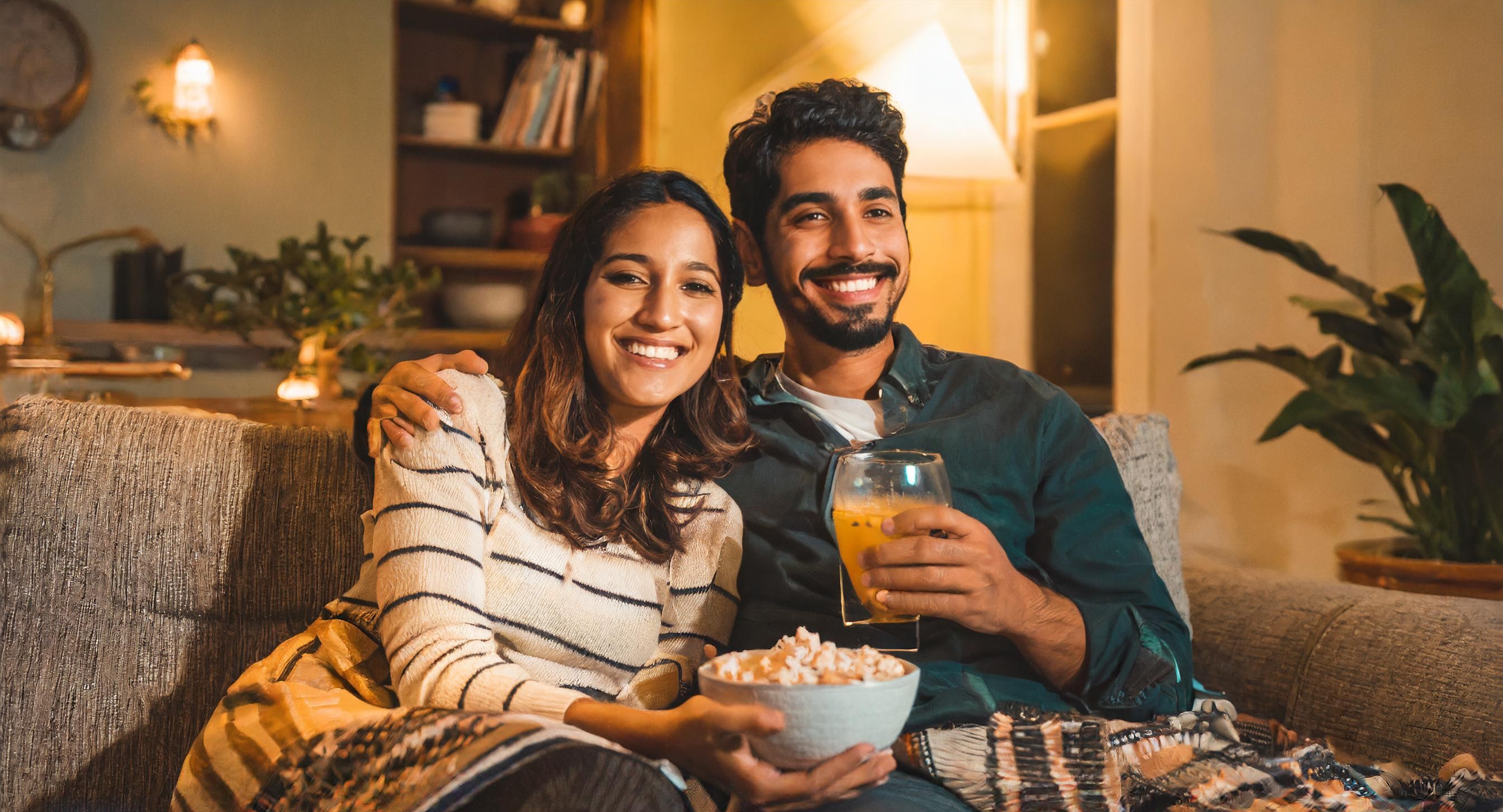 couple regardant la TV avec popcorns et boisson