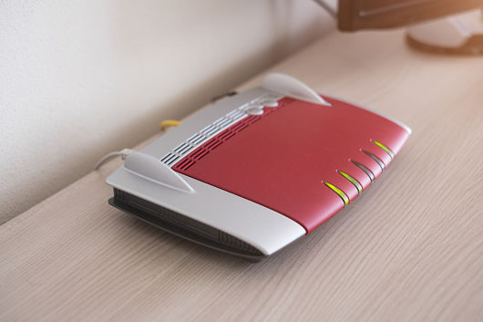 Un modem allumé et branché est posé sur une table