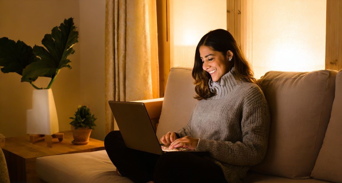 femme sur son canapé utilisant son ordinateur