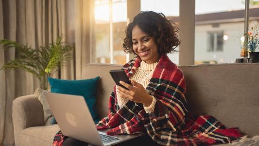 femme utilisant son ordinateur et son téléphone